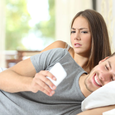 Jealous woman spying her husband mobile phone Jealous woman spying her husband mobile phone while he is reading a message