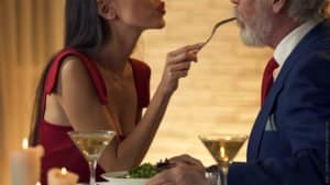 Großer Altersunterschied bei Paaren - Was tun um sich gegenseitig zu stärken. Junge Frau füttert älteren Herrn im Restaurant.