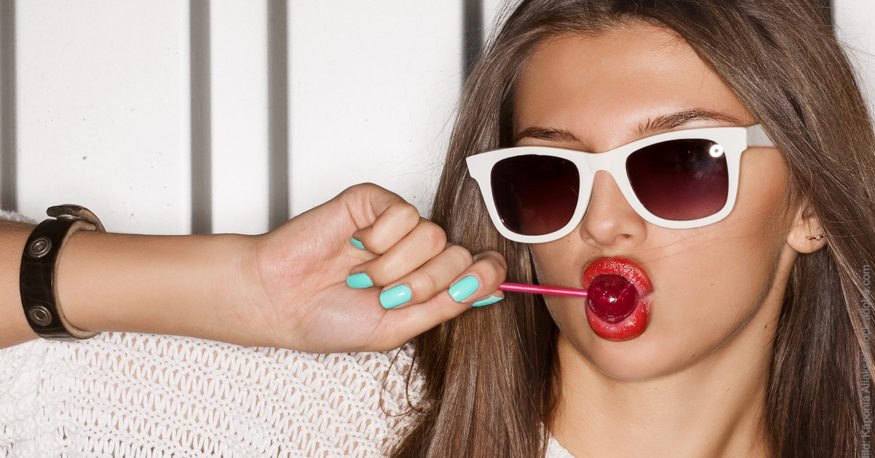 Was beeinflusst das Selbstwertgefühl: 4 Faktoren: Junge Frau mit roten Lippen lutscht einen Lolli.