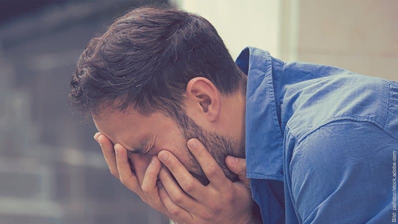 Trennung auf Zeit - gut oder schlecht? Mann stütz sein Gesicht in die Hände. Er sieht traurig aus.