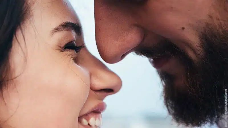 Wie entsteht Partnerschaft? Junge Frau und junger Mann schauen sich zärtlich an, dabei sind ihre Gesichter sich sehr nahe.