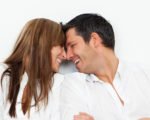 Zusammenziehen - 12 Fragen, die du vorher klären musst. Mann und Frau stecken zärtlich ihre Köpfe zusammen.
