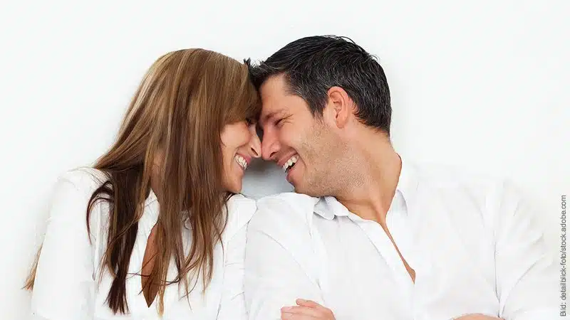 Zusammenziehen - 12 Fragen, die du vorher klären musst. Mann und Frau stecken zärtlich ihre Köpfe zusammen.