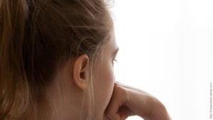 Einsamkeit nach der Trennung: Junge Frau von hinten, schaut in die Ferne.