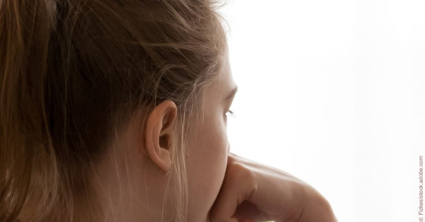 Einsamkeit nach der Trennung: Junge Frau von hinten, schaut in die Ferne.