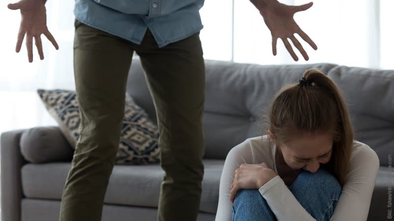 Selbst Schuld am Fremdgehen des Partners? Frau sitzt weinend auf dem Boden, Mann steht bedrohlich über ihr.