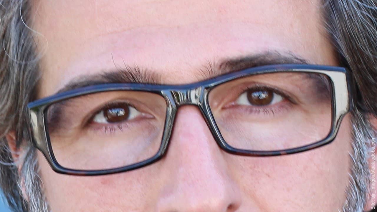 Wie wirken Streit und Stress in der Partnerschaft? Brille tragender Mann mit traurigen Augen. Er hat vermutlich Streit oder Stress in seiner Partnerschaft.