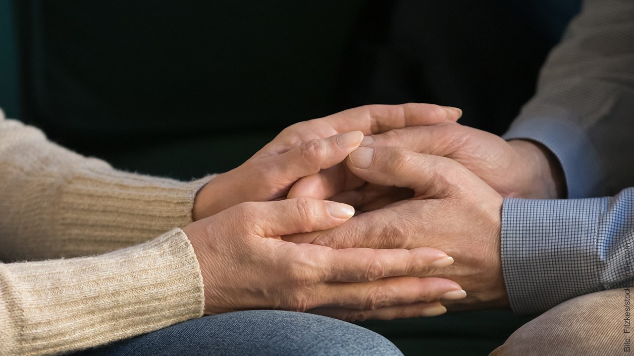 Streit beenden. Mann und Frau legen ihre Hände ineinander.