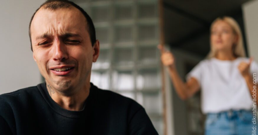 Scheidung: Mann weint verzeifelt, Frau mit erhobenen Zeigefingern im Hintergrund